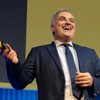 Lee Hayhurst on stage speaking at an event.